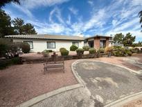 Charming ranch-style home featuring a well-maintained yard, mature landscaping, and a cozy front bench at 10561 Rancho Destino Rd, Las Vegas, NV 89183