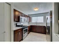 Well-lit kitchen features stainless steel appliances, wooden cabinets, and light countertops at 1550 Jamielinn Ln # 102, Las Vegas, NV 89110