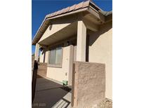Inviting front porch featuring a secure, tan-colored block-wall surrounding the entry with stone flooring at 2050 N Los Feliz St # 114, Las Vegas, NV 89156