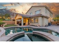 Inviting backyard features a pool, spa, covered patio, and lush lawn perfect for outdoor entertaining at 4573 Milvio Ave, Las Vegas, NV 89141