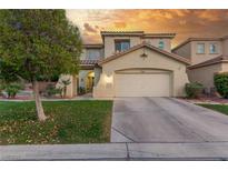 Two-story home featuring a red tile roof, arched windows, and a well-manicured lawn at 4573 Milvio Ave, Las Vegas, NV 89141