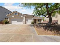 Charming single-story home featuring a three-car garage and beautifully landscaped front yard with mature shade tree at 51 La Fiesta St, Henderson, NV 89012