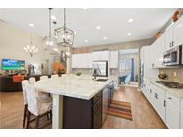 Bright, modern kitchen features a large island with seating and stainless steel appliances at 5523 Kyle Peak Ct, Las Vegas, NV 89135