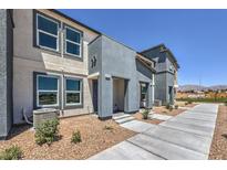 Modern two-story home featuring stylish gray and white stucco and a well-maintained gravel yard at 6112 Aster Garden St # 131, North Las Vegas, NV 89081
