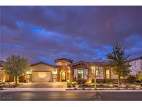 Charming single story home with stone accents, a three car garage and manicured landscaping at twilight at 62 Grand Masters Dr, Las Vegas, NV 89141