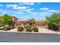 Inviting single-story home with a three-car garage and well-manicured landscaping on a sunny day at 9812 Turtle Walk Ave, Las Vegas, NV 89149