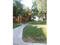 Lush green community grounds with mature trees and well-maintained pathways for a serene living environment at 1303 Darlene Way # 302C, Boulder City, NV 89005