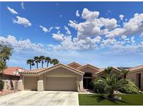Charming single-story home featuring a two-car garage, desert landscaping and tile roof under a partly cloudy sky at 2986 Matese Dr, Henderson, NV 89052