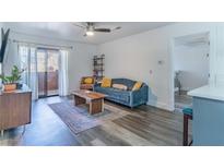 Cozy living room featuring modern furniture, a ceiling fan, and sliding doors to a balcony at 3151 Soaring Gulls Dr # 2002, Las Vegas, NV 89128