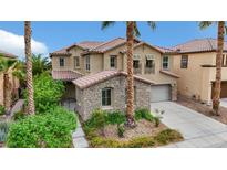 Charming two-story home featuring a stone facade, lush landscaping, and a tile roof, offering curb appeal at 3217 Palladio Ave, North Las Vegas, NV 89031