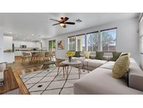Bright, open living space features large windows, ceiling fan, and flows into a modern kitchen and dining area at 3217 Palladio Ave, North Las Vegas, NV 89031