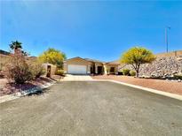 Charming single-story home featuring a desert landscape and a two-car garage at 3567 Cottage Stream Ct, Laughlin, NV 89029