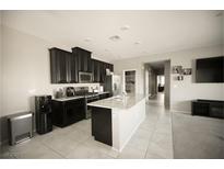 Spacious kitchen features dark cabinets, stainless appliances, and a large center island at 4465 Shimmering Skies St # 2180, North Las Vegas, NV 89031