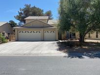 Charming home featuring a wide driveway leading to a two-car garage and a well-maintained front yard at 5540 Singing Hills Dr, Las Vegas, NV 89130
