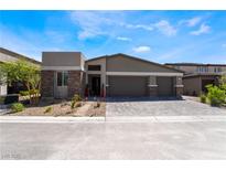 Charming single-story home featuring a three-car garage and stone accents on the facade, set against a clear blue sky at 9565 Camelback Creek Dr, Las Vegas, NV 89178