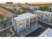 Modern townhome with a flat roof and balconies in a vibrant community setting with views of the Las Vegas skyline at 11485 Vibrant Heights Dr # 32, Las Vegas, NV 89135