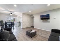 Bright living room featuring hardwood floors, comfortable seating, and a sliding glass door to the dining area at 3120 S Eastern Ave # 6, Las Vegas, NV 89169