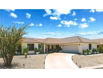Charming single-story home featuring a tile roof, attached garage, and drought-tolerant landscaping at 40 Palm Gardens Dr, Palm Gardens, NV 89039