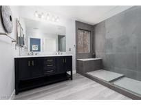 Modern bathroom features double vanity with marble countertop and oversized shower with window at 689 Principle Point Ave, Henderson, NV 89012