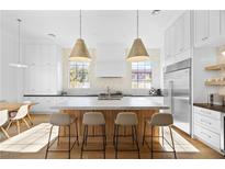 Bright and modern kitchen featuring a large island, stainless steel appliances and stylish pendant lighting at 10969 Tranquil Waters Ct, Las Vegas, NV 89135