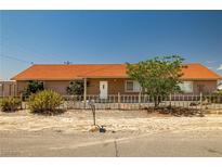 Single story home featuring a well-maintained yard, complemented by mature landscaping, and a charming fence at 2090 S Ambush St, Pahrump, NV 89048