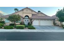 Charming single-story home featuring a lush front yard, stone accents, and a two-car garage at 2559 Purple Heather Pl, Henderson, NV 89052