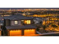 Spectacular home showcasing illuminated city views, balcony, and two-car garage at 460 Pear Lake St, Las Vegas, NV 89138