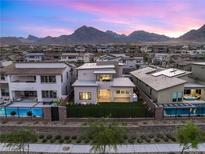 Stunning rear exterior view of a modern two-story home with a pool and mountain views at 484 Windstone Crest Ave, Las Vegas, NV 89138