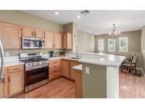 Bright kitchen with stainless steel appliances, wood cabinets, and eat-in breakfast bar at 10191 Deerfield Beach Ave # 202, Las Vegas, NV 89129