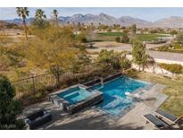 Inviting backyard featuring a sparkling pool, spa, and mountain views, perfect for outdoor relaxation and entertainment at 2215 Alcova Ridge Dr, Las Vegas, NV 89135