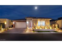 Charming single-story home featuring manicured landscaping and a brick-accented two-car garage under a moonlit sky at 3000 Dusky Willow Ln, Las Vegas, NV 89138