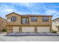 Inviting townhouse with tan exterior and multiple garage spaces, set against a clear blue sky at 6255 W Arby Ave # 118, Las Vegas, NV 89118