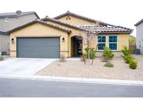 Inviting single-story home featuring low-maintenance landscaping, a gray two-car garage, and a neutral color palette at 645 Turtleback Falls Ave, Indian Springs, NV 89018