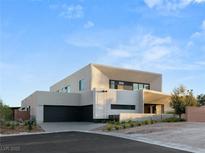 Contemporary two-story home featuring stucco exterior, flat roof, attached two car garage, and desert landscaping at 7385 Heron Canyon Ct, Las Vegas, NV 89117