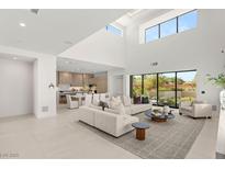Bright, open-concept living room features modern decor, high ceilings, and abundant natural light from large windows at 7385 Heron Canyon Ct, Las Vegas, NV 89117