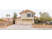 Two-story home features a two-car garage, well-maintained landscaping, and desert surroundings at 7445 Shangri La Ave, Las Vegas, NV 89147