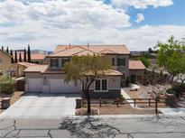 Inviting two-story home featuring a three-car garage and beautiful desert landscaping at 7569 Shadow Estates Way, Las Vegas, NV 89113