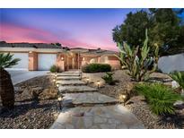 Charming home featuring a stone pathway with solar lighting and desert landscaping at 8216 W Hammer Ln, Las Vegas, NV 89149