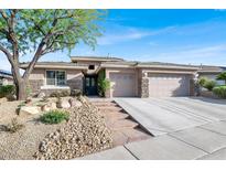 Beautiful single-story home with stone accents, well-manicured landscaping, and an attached two-car garage at 10309 Canyon Valley Ave, Las Vegas, NV 89145