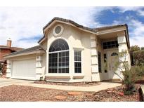Charming single-story home with desert landscaping, two-car garage, and large arched window at 128 Golf Course St, Las Vegas, NV 89145