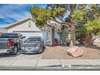 Charming single-story home featuring a two-car garage, desert landscaping, and mature shade tree at 2301 Cambridge Elms St, North Las Vegas, NV 89032