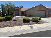Charming single-story home featuring a well-maintained front yard with mature landscaping and a two-car garage at 2708 Hope Forest Dr, Las Vegas, NV 89134