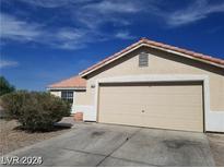 Exterior shot featuring a two car garage and blue skies at 3012 Silver Canyon Ln, North Las Vegas, NV 89031