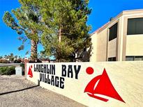 Laughlin Bay Village community sign with mature trees and clear blue sky in the background at 3740 Desert Marina Dr # 12, Laughlin, NV 89029