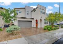 Modern two-story home featuring a two-car garage, arched entryway, and drought-tolerant landscaping at 525 Monarch Ridge Ct, North Las Vegas, NV 89084