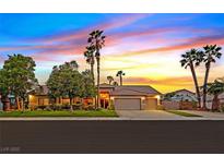 Beautiful single-story home featuring a well-manicured lawn, mature trees and a two-car garage at 6345 Cinnabar Ridge Ave, Las Vegas, NV 89130