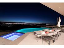 Inviting pool and spa area with comfortable lounge chairs overlooking a stunning city view at twilight at 661 Dragon Peak Dr, Henderson, NV 89012