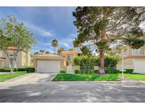 Charming home featuring a well-manicured lawn, mature trees, and a two-car garage at 8221 Crow Valley Ln, Las Vegas, NV 89113