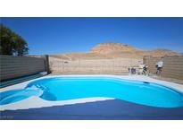 Backyard in ground pool with blue water and surrounding desert landscape offers a tranquil outdoor retreat at 83 Rock Run St, Las Vegas, NV 89148