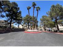 Community entrance featuring mature trees and verdant foliage at 8940 Clairton Ct, Las Vegas, NV 89117